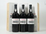 trois bouteilles de vin dans un coffret en bois sur une surface blanche