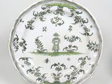 une assiette verte et blanche sur laquelle est représenté un nichoir