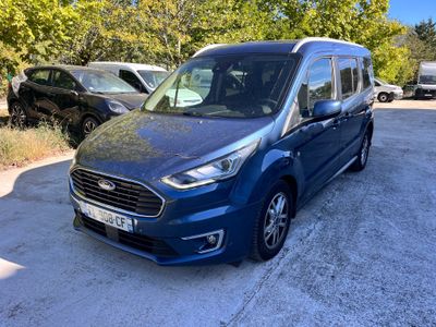 une camionnette bleue garée sur un parking à côté d'une forêt