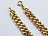 a close up of a pair of gold chains on a white surface