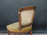 an old wooden chair with a tan upholstered seat