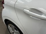 a close up of a car door handle on a white car