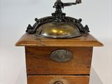 an old fashioned coffee grinder with a brass plate on top of it