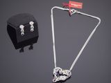 une photo d'un ensemble composé d'un collier et de boucles d'oreilles posé sur une table
