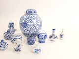de nombreux vases bleus et blancs posés sur une surface blanche