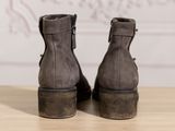 the back view of a pair of grey boots on a wooden table