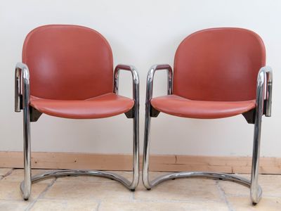 two red chairs sitting next to each other on the floor