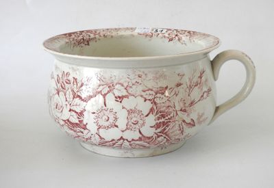 a red and white bowl with a handle on a white table