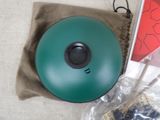 a green ball sitting on top of a bag next to a cell phone