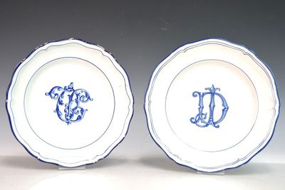 une paire d'assiettes bleues et blanches ornées de lettres formant un monogramme