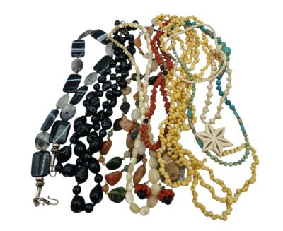 a lot of necklaces that are on a white surface