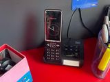 un téléphone portable posé sur une table rouge à côté d'une tasse de café