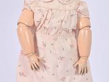 a doll that is wearing a dress and a hat