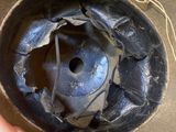 a hand holding a helmet that has a hole in it