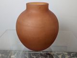 a small brown vase sitting on a glass table
