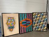 three framed art pieces sitting on the floor in a room