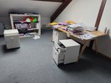 deux bureaux dans un coin d'une pièce où se trouve une télévision