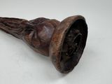 a wooden pipe with a face on it on a table
