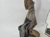 a statue of a woman with a hat and a mirror