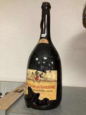 une bouteille de vin posée sur une table à côté d'une lampe