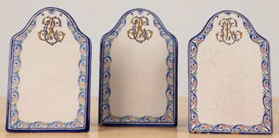 three blue and white plates with monograms on them