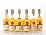 un lot de six bouteilles de whisky posées sur une surface blanche