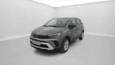 Une voiture grise est garée dans une pièce blanche au sol blanc.
