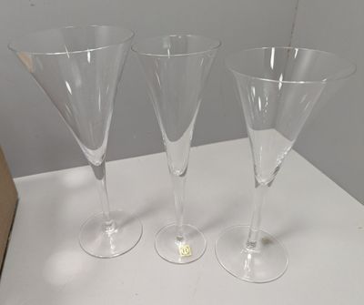 trois verres à vin vides posés sur une table blanche