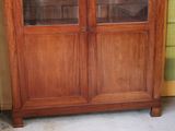 a wooden cabinet with glass doors in a room
