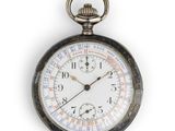 une montre de poche en argent exposée sur une surface blanche
