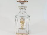 crystal decanter with a gold - plated emblem on the top