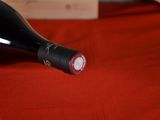a bottle of wine sitting on a red table cloth
