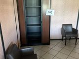 two chairs and a bookcase in the corner of a room