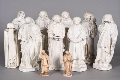 statue of a group of people dressed in white standing next to each other