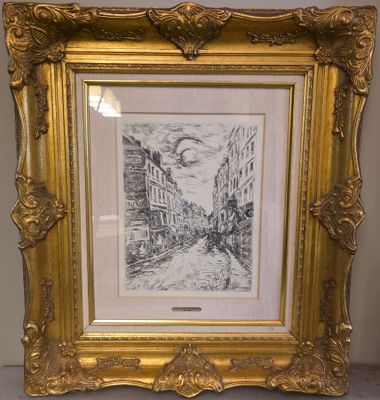 un cadre doré dans lequel figure un dessin représentant une scène de rue