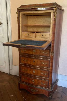 a small desk with a drawer on it in the corner of a room