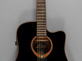 a black acoustic guitar hanging on the wall