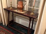 une table sur laquelle est posé un vase, devant une fenêtre