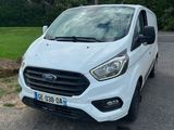 une fourgonnette Ford Transit blanche garée sur un parking