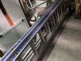 a long line of machines in a warehouse with boxes on the floor