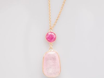 un pendentif en pierre rose avec une chaîne en or sur fond blanc