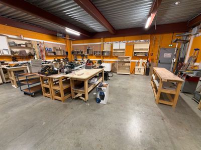 une photo d'un atelier avec de nombreux établis et tables de travail
