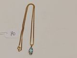 un collier en or orné d'une topaze bleue et d'une chaîne en or