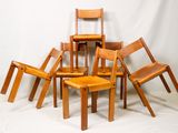 plusieurs chaises en bois et une table dans une pièce avec un fond blanc