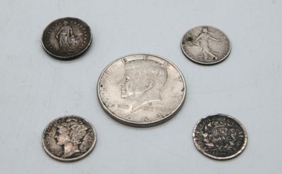a close up of a silver coin and five other coins
