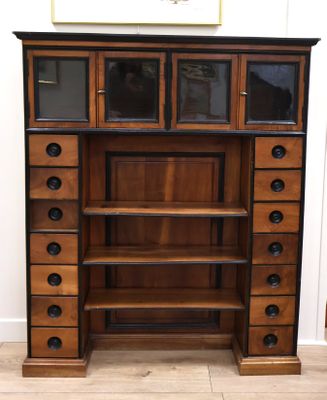 une grande armoire en bois comportant de nombreux tiroirs et étagères