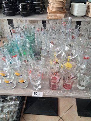 bottles and glasses on a table in a store with a price tag