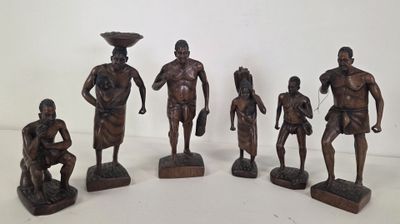 six bronze figurines of african men with bowls on their heads