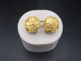 a close up of a pair of gold earrings on a white box