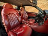 the interior of a car with red leather seats and a black steering wheel